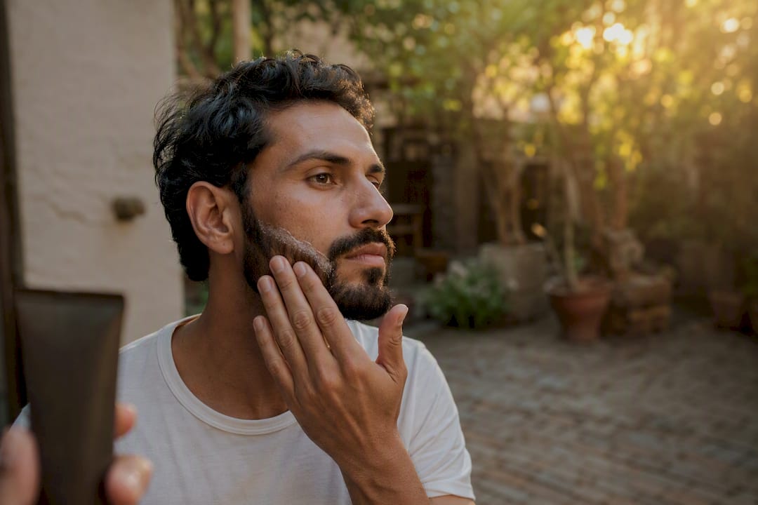 Man applying sunscreen on beard edges