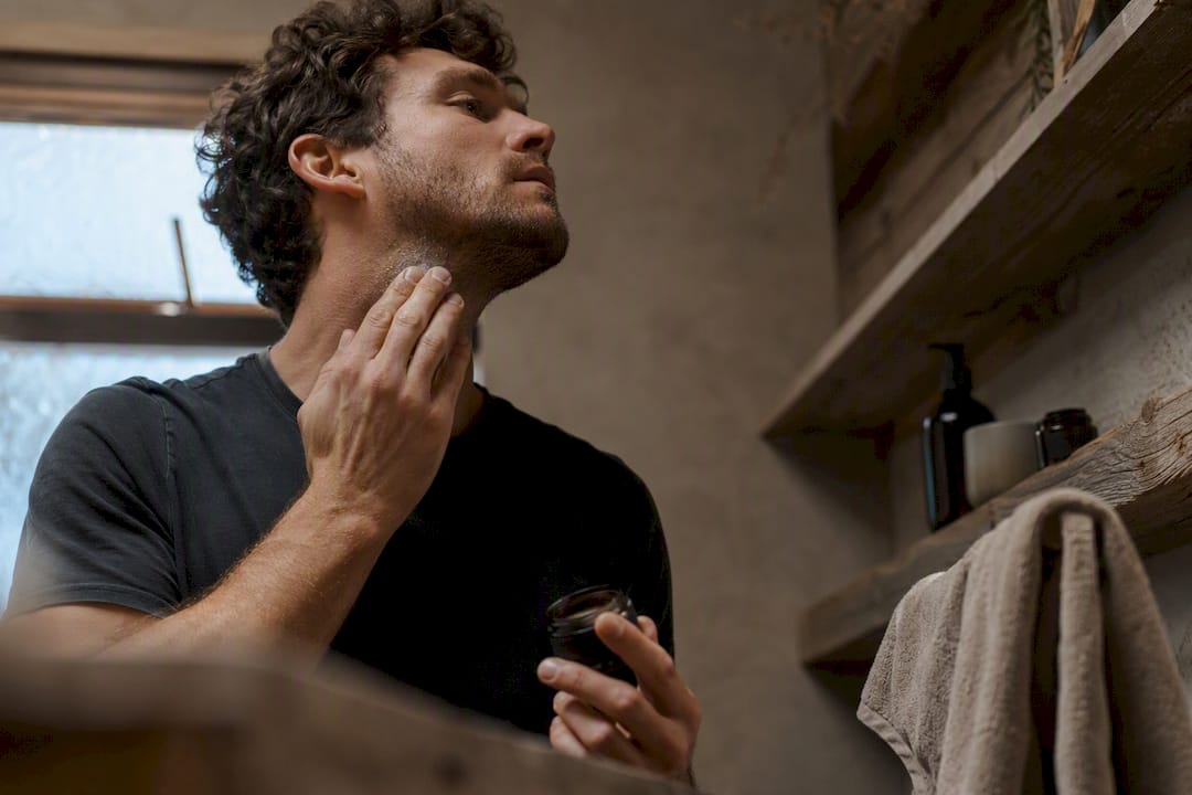 Man patch testing natural balm on jawline