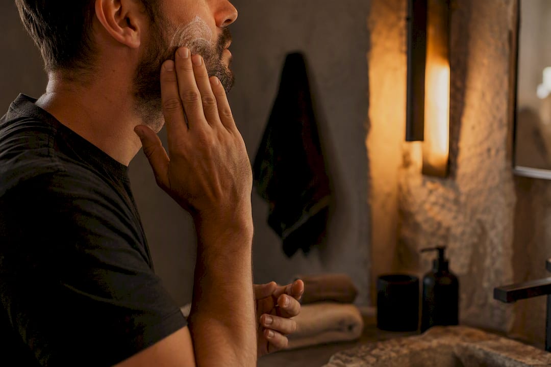 Man applying face balm at night