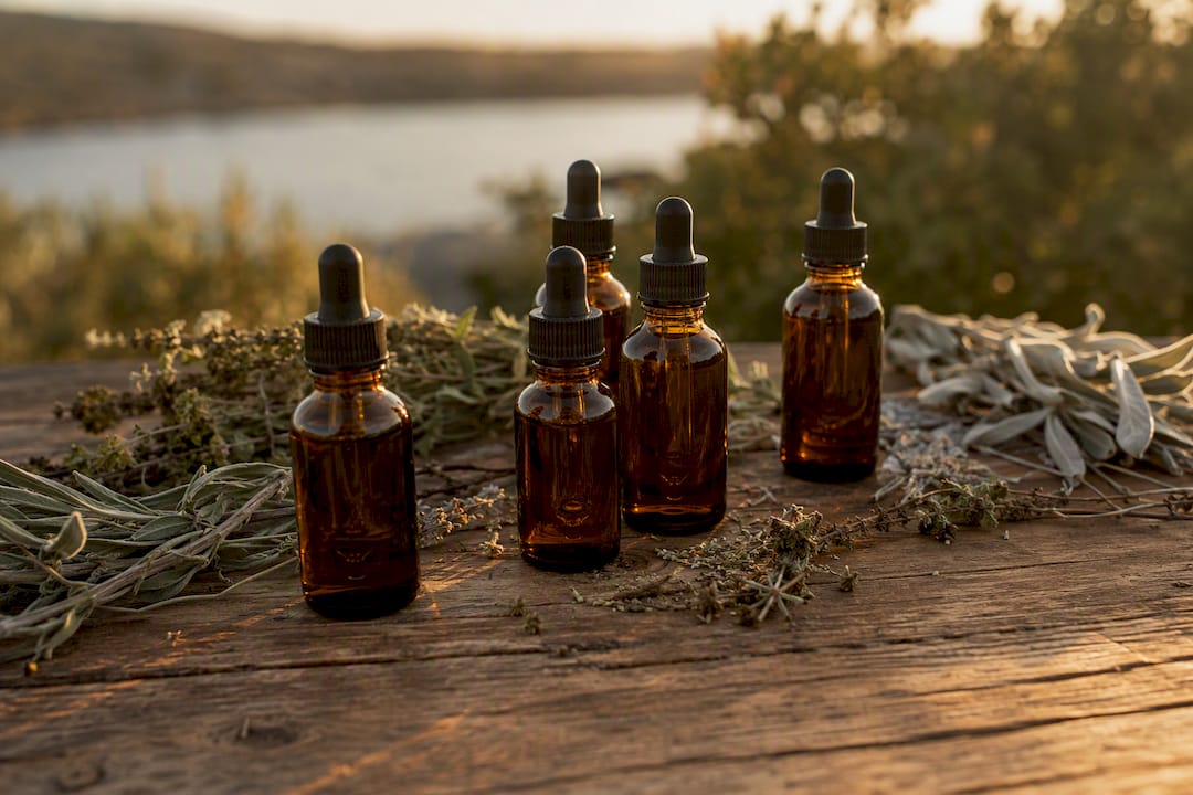 Natural beard oils and dried herbs on wood