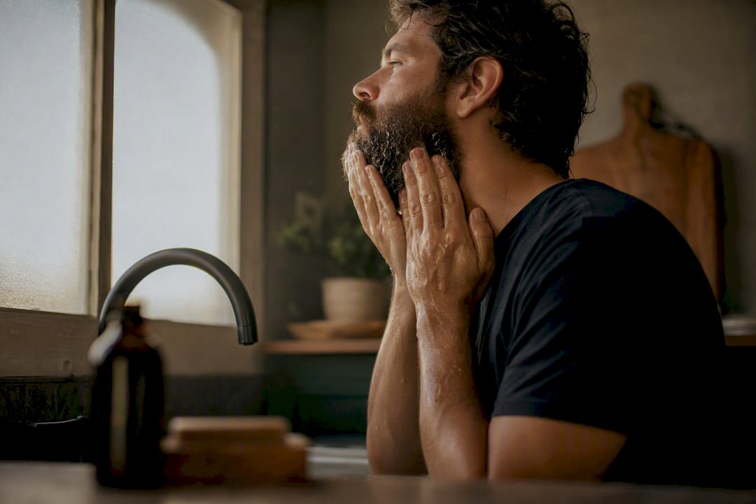 Man washing beard with antifungal treatment