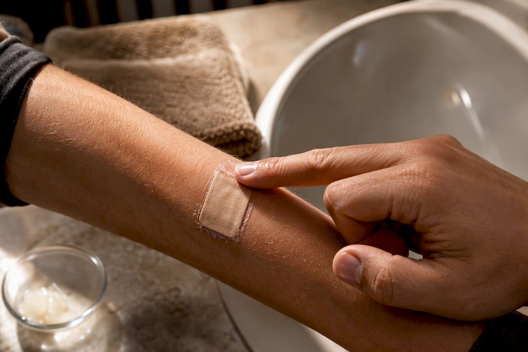 Applying petroleum jelly beside a bandage