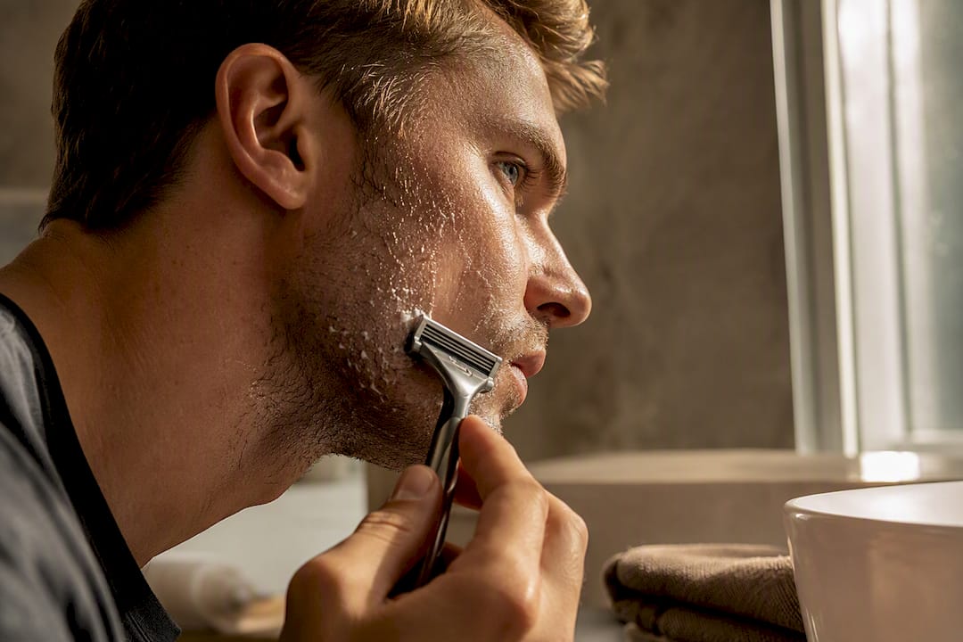 Man shaving damp facial stubble