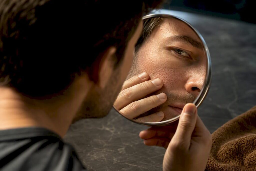 Man inspecting congested facial skin
